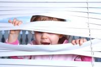 Kind hinter Innenbeschattung